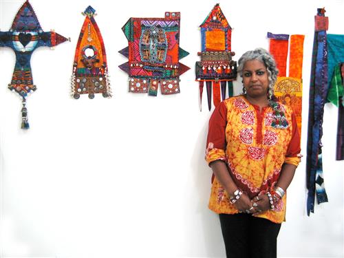 color photo of a woman standing in front of artwork